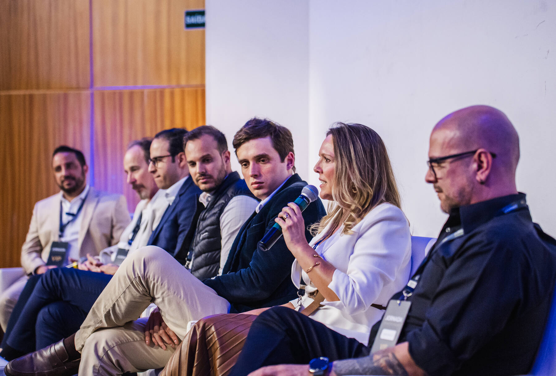 Painel de debate com sete convidados no palco da Jornada 2025