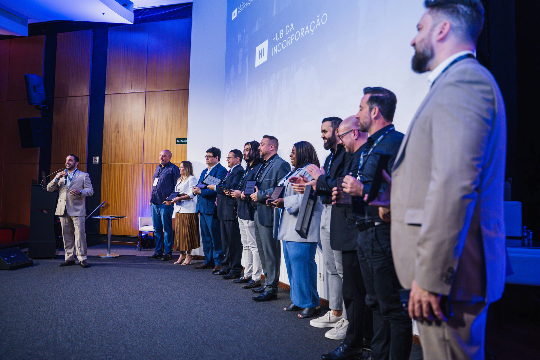 Premiação do Hub da Incorporação no palco, com homenageados enfileirados